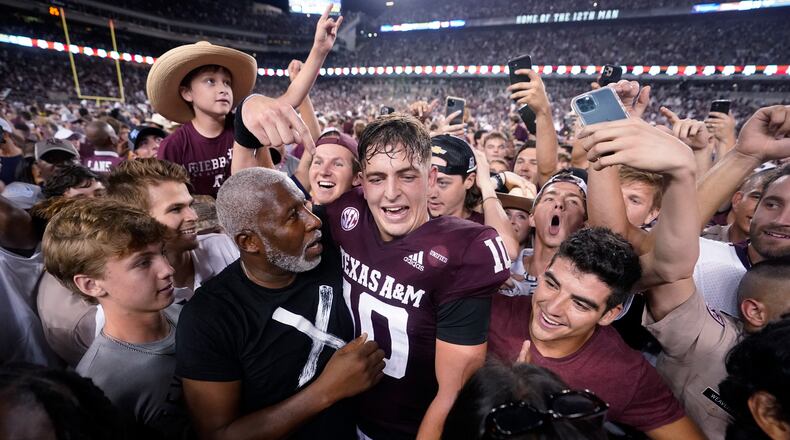 Texas A&M quarterback Zach Calzada (10) is surrounded by fans after the team's win over Alabama in an NCAA college football game Saturday, Oct. 9, 2021, in College Station, Texas. (AP Photo/Sam Craft)