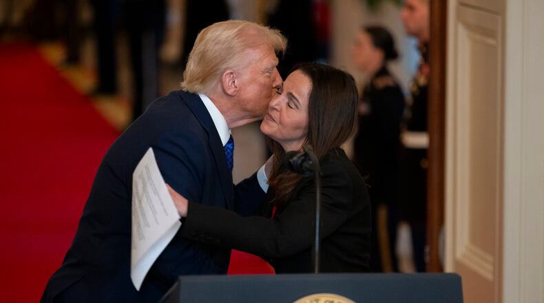 Allyson Phillips, mother of Laken Riley, and President Donald Trump embrace ahead of the Jan. 29 signing of the Laken Riley Act in the East Room of the White House in Washington. (Nathan Posner for The Atlanta Journal-Constitution)