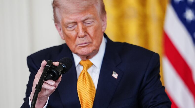 President Donald Trump adjusts his microphone while speaking during an event for military mothers in the East Room of the White House, Wednesday, May 6, 2026, in Washington. (AP Photo/Julia Demaree Nikhinson)