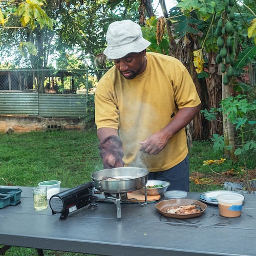 Rashad Frazier prepares food outdoors in Lava Lands, Ore., on Aug. 7, 2024. (Alex Forestier via AP)