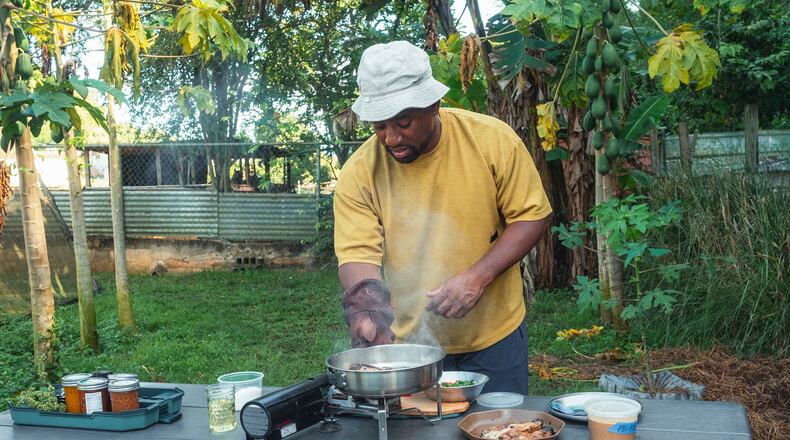 Rashad Frazier prepares food outdoors in Lava Lands, Ore., on Aug. 7, 2024. (Alex Forestier via AP)