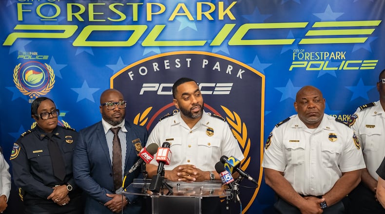 Forest Park police Chief Brandon Criss (center) gives an April 28 update on a fatal shooting at a body shop on 1st Street that happened the day before. Two people were killed and two injured. (Ben Hendren for the AJC)