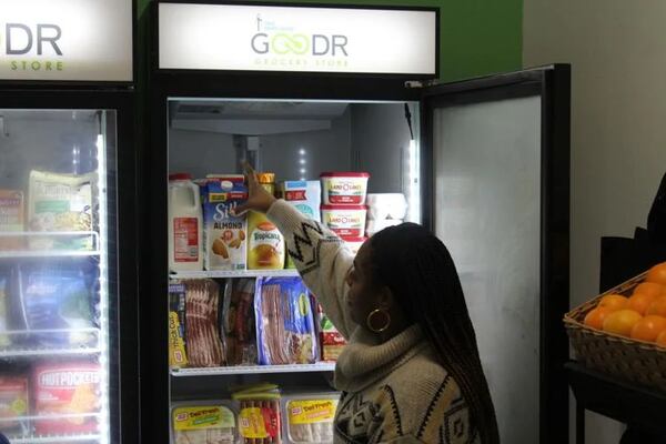 Tapp Middle School PTSA Vice President Egyptian Howell-Proano peruses the refrigerated goods during the ribbon cutting ceremony for the Goodr food pantry. (Photo Courtesy of Brian McKeithan)