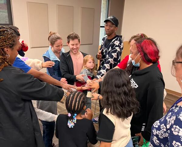 Children and parents join with Malcolm Mitchell after he read from his latest children’s book. (Claudia Strange/Fulton County Library System)