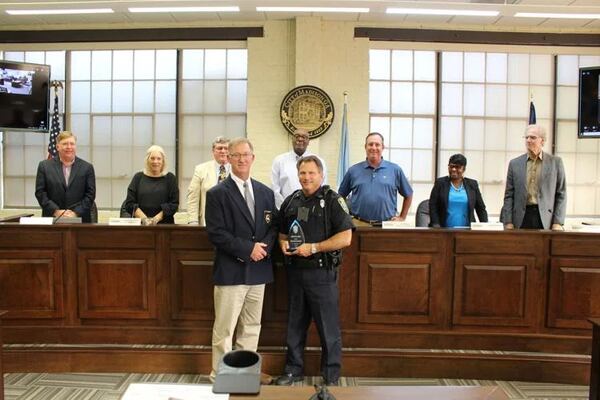 Madison Police Chief Bill Ashburn, left, presents Officer Mike Maxwell, right, with the City of Madison's Lifesaving Award for his prompt response and quick thinking in saving the life of a newborn baby. (Courtesy of Ken Kocher)