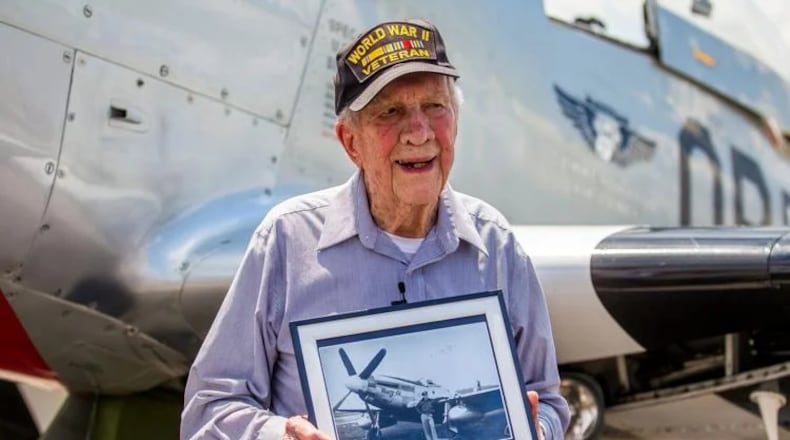 James McCubbin holds a picture of himself next to his original P51 Mustang back in World War II. Last week, McCubbin was reunited with the same model at Richard B. Russell Regional Airport.