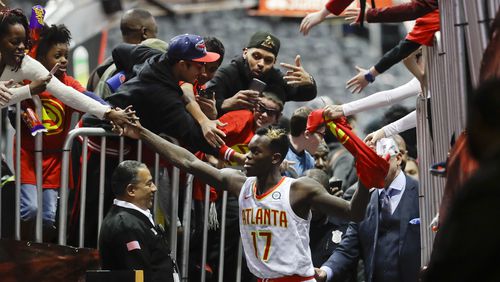 Atlanta Hawks guard Dennis Schroder is mobbed by fans as he leaves the court following their 102-99 win over the San Antonio Spurs in an NBA basketball game Monday, Jan. 15, 2018, in Atlanta. (AP Photo/John Bazemore)
