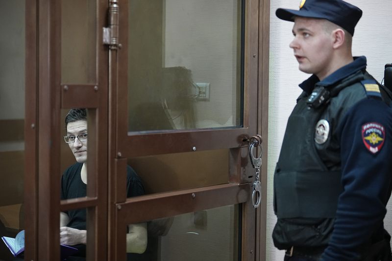 U.S. citizen Robert Woodland Romanov, left, sits in a glass cage prior to a court session on drug-related charges in Moscow, Russia, on Thursday, April 25, 2024. The U.S. citizen arrested on drug charges in Moscow amid soaring Russia-U.S. tensions has appeared in court. Robert Woodland Romanov is facing charges of trafficking large amounts of illegal drugs as part of an organized group — a criminal offense punishable by up to 20 years in prison. (AP Photo/Alexander Zemlianichenko)
