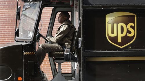 A UPS driver on a delivery route in New York. UPS is adding a new charge of under $1 for shipments to residential customers during peak delivery periods in November and December. (AP Photo/Mark Lennihan)
