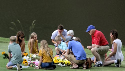 Mourners gather at a memorial for Gene Siller, a man shot and killed Saturday, at Pinetree Country Club in Kennesaw on Friday, July 9, 2021. Two other men were found dead in the bed of a pickup truck at the country club course. Bryan Rhoden, 23, was arrested Thursday for the killings. (Christine Tannous / christine.tannous@ajc.com)