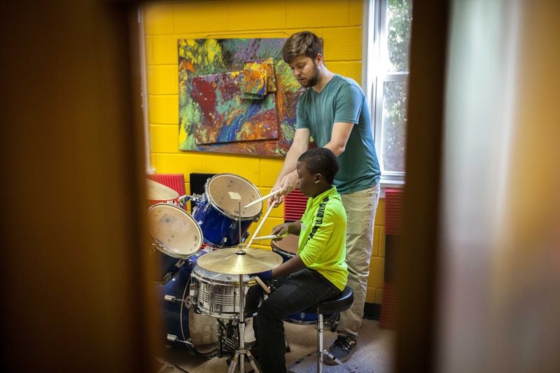 JT Lewis (top) gives Prince Babonye, 11, a drum lesson at Proskuneo, a music school in Clarkston that provides free lessons every Saturday morning on a variety of instruments. BRANDEN CAMP/SPECIAL