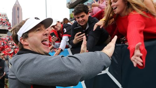 Georgia football head coach Kirby Smart high fives fans after beating Georgia Tech 38-7 in Atlanta. Will fans of UGA and other universities be less willing to buy season tickets if a juicy tax deduction is eliminated? Curtis Compton/ccompton@ajc.com