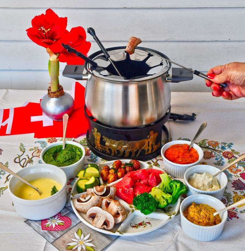 Beef Fondue can be served with a variety of sauces (international sauces may include chimichurri, bearnaise, sour cream and horseradish or peanut satay), mushrooms, broccoli, zucchini, roasted potatoes and a simple green salad. (Styling by Lisa Hanson / Chris Hunt for the AJC)