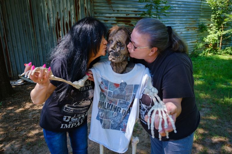 Debbie DiMuro (left) of Florence, Kentucky, and Tonya Hammel of Newport, Kentucky, are seen with a skeleton named George during a July visit to Senoia. They are fans of "The Walking Dead." Arvin Temkar/arvin.temkar@ajc.com
