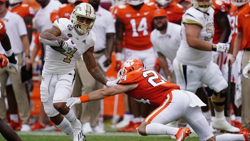 Georgia Tech running back Dontae Smith tries to get away from Clemson linebacker Trenton Simpson during a game in 2021. Starting in the fall semester, Tech athletes will be eligible to receive up to $5,980 per academic year in cash through an academic-performance rewards program that became part of NCAA legislation in 2020. (AP Photo/John Bazemore)
