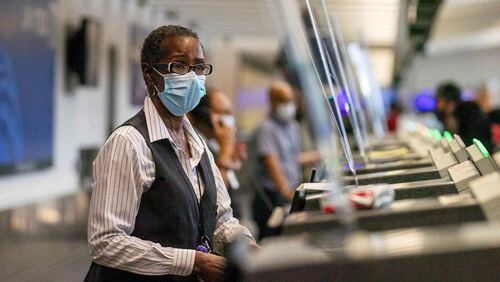 09/04/2020 -Atlanta, Georgia - United Airlines customer service agent Wendy Payne wears a mask as she works with a customer at a ticket counter in the domestic terminal at Hartsfield-Jackson Atlanta International Airport, Friday, September 4, 2020. (Alyssa Pointer / Alyssa.Pointer@ajc.com)