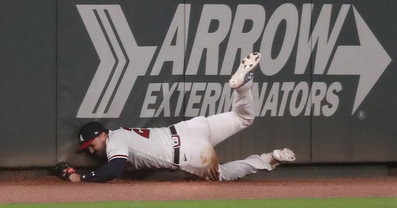Braves outfielder Adam Duvall runs down a long fly ball by Tampa Bay Rays Jose Martinez and manages to hold on while crashing into the wall during the ninth inning Thursday, July 30, 2020, at Truist Park in Atlanta. The Braves held on for the 2-1 win.
