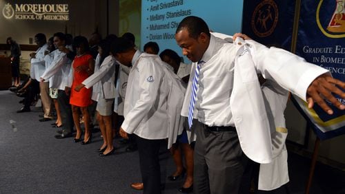 MEDICAL STUDENT TRADITION--First year medical student Dorian Wood dons his white coat during the Morehouse School of Medicine Annual White Coat Ceremony in this AJC file photo. MSM is one of four Black medical schools in the U.S.