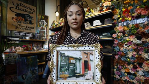 LaRayia Gaston, the owner of LaRayia's Bodega located within Ponce City Market, holds a frame with a photo of the first store she opened in Los Angeles. The bodega relocated to Atlanta last year.
Miguel Martinez /miguel.martinezjimenez@ajc.com
