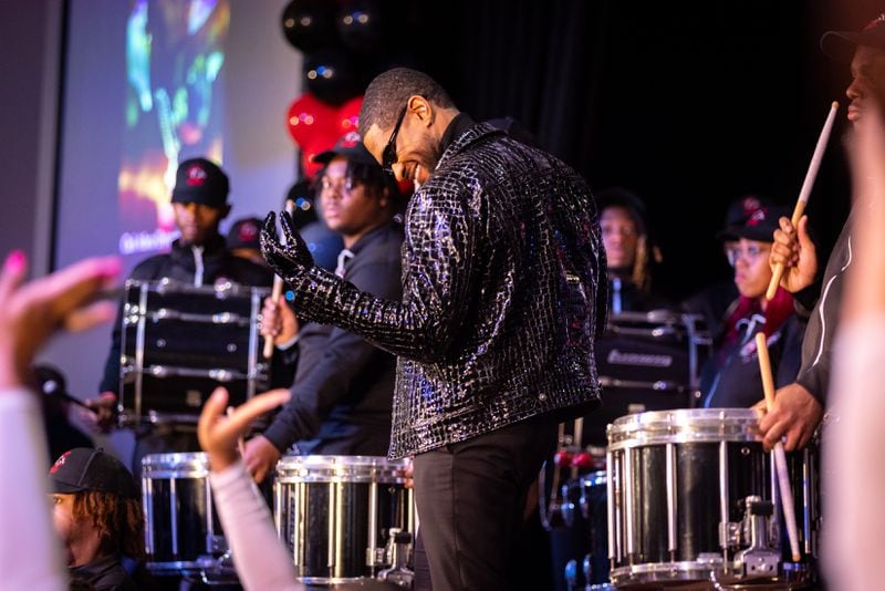 Usher appears for a homecoming rally at Clark Atlanta University in Atlanta on Wednesday, February 14, 2024, while the CAU marching band plays. Along with other honors, Amazon presented a $25,000 donation to Usher’s New Look Foundation. (Arvin Temkar / arvin.temkar@ajc.com)