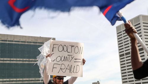 11/5/20 - Atlanta - A President Donald Trump supporter holds a sign outside of State Farm Arena as Fulton County employees work inside, finishing up the ballot counting process.  Demonstrators were outside of State Farm Arena where absentee ballots were counted.   (Alyssa Pointer / Alyssa.Pointer@ajc.com)