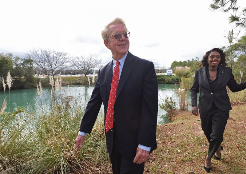 Aflac CEO Dan Amos and senior vice president Shannon Watkins walk near a duck pond on the insurance company’s satellite corporate campus in Columbus. Aflac TV commercials starring a duck were launched 20 years ago this month, boosting the company’s financial trajectory. (Hyosub Shin / Hyosub.Shin@ajc.com)