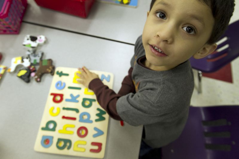 A Pre-K student works on a alphabet puzzle which helps with fine motor skills.