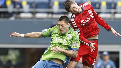 Seattle Sounders FC midfielder Clint Dempsey (2) and Toronto FC defender Mark Bloom (28) jump for a header during the first half at CenturyLink Field. Joe Nicholson-USA TODAY Sports