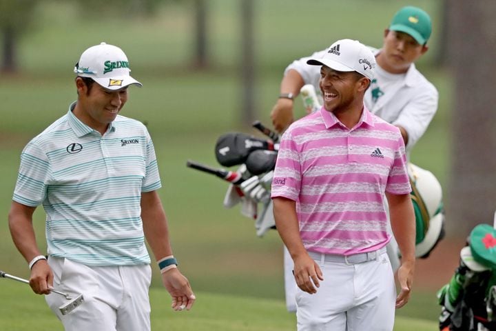 April 10, 2021, Augusta: Hideki Matsuyama, left, reacts after making an eagle on the fifteenth hole with Xander Schauffele during the third round of the Masters at Augusta National Golf Club on Saturday, April 10, 2021, in Augusta. Curtis Compton/ccompton@ajc.com