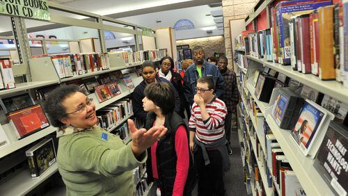 In this 2013 file photo, Karen Harris (left), manager of the Norcross branch of the Gwinnett Public Library System, leads a tour group.