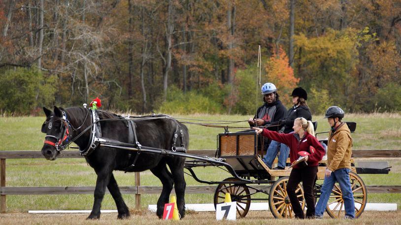 Jonathan Babineaux (left) on a training ride where he learned the fundamentals of driving a carriage from Carey Siegel. Walking along with them are Driving Magic's Executive Director Jennifer Lindskoog (left) and Jackie Griswold. BANDRES@AJC.COM