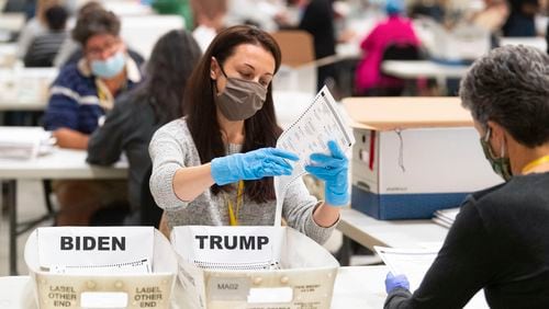 An election worker looks at a ballot during a hand recount of Presidential votes on Sunday, Nov.15, 2020 in Marietta, Ga. (John Amis/Atlanta Journal & Constitution via AP) 
