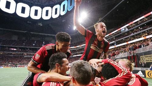 Atlanta United midfielder Miguel Almiron is swarmed by teammates after scoring his team’s second goal of the night on a penalty kick for a 2-0 lead over New York City during the first half in their MLS Eastern Conference Semifinal playoff match on Sunday, Nov. 11, 2018, in Atlanta. Atlanta advanced.