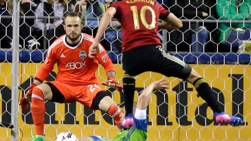Seattle Sounders goalkeeper Stefan Frei, upper left, position to stop a shot by Atlanta United midfielder Miguel Almiron (10) as Almiron leaps over Sounders’ Osvaldo Alonso in the second half of an MLS soccer match, Friday, March 31, 2017, in Seattle. The match ended in a 0-0 tie. (AP Photo/Ted S. Warren)