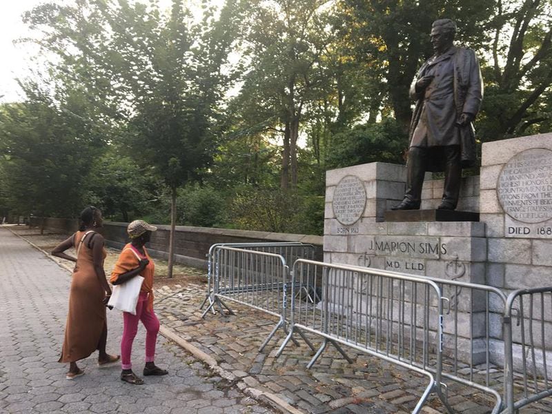 Sharon Thompson, in the dress, and her mother, Louise Thompson study a statue of J. Marion Sims in Central Park in New York City on Monday, Aug. 21, 2017.