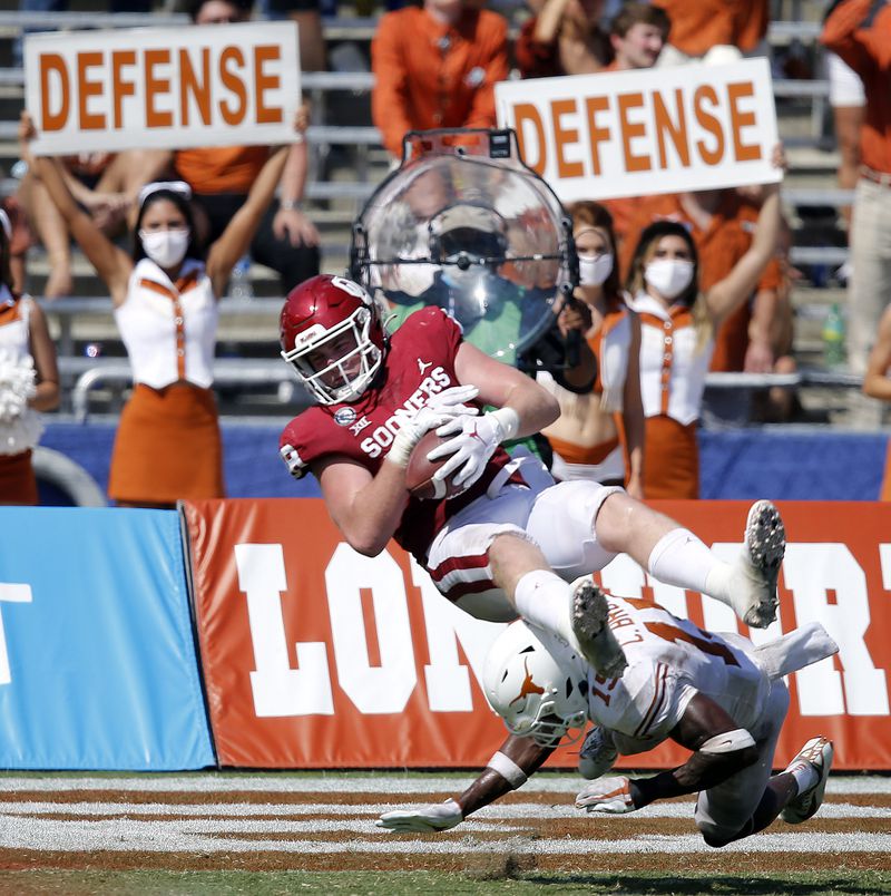 Oklahoma running back Austin Stogner (18) flies through the air as he makes a leaping catch in front of Texas defensive back Chris Brown (15) during the third quarter at the Cotton Bowl in Dallas on Saturday, Oct. 10, 2020. Oklahoma won in quadruple overtime, 53-45. (Tom Fox/Dallas Morning News/TNS)