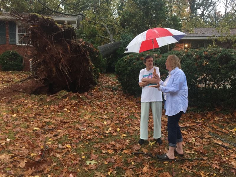 Martha Jane Jones (left) talks with her neighbor at her home off Northside Parkway in Atlanta where a tree fell during Wednesday's storms. (Credit: Branden Camp / Special)