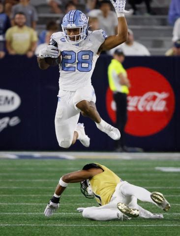 North Carolina Tar Heels running back Omarion Hampton (28) leaps over Georgia Tech Yellow Jackets defensive back Myles Sims (0) during the second half of an NCAA football game In Atlanta on Saturday, Oct. 28, 2023 between the Georgia Tech Yellow Jackets and the North Carolina Tar Heels.  Georgia Tech won, 46-42.  (Bob Andres for the Atlanta Journal Constitution)