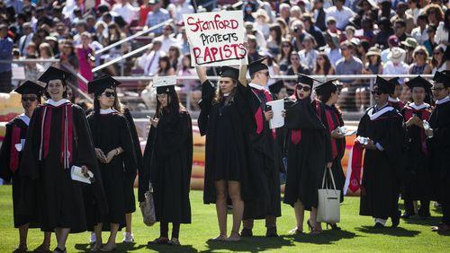 STANFORD, CA - JUNE 12: Graduating student, Andrea Lorei, who help organize campus demonstrations holds a sign in protest during the 'Wacky Walk' before the 125th Stanford University commencement ceremony on June 12, 2016 in Stanford, California. The university holds its commencement ceremony amid an on-campus rape case and its controversial sentencing. (Photo by Ramin Talaie/Getty Images)