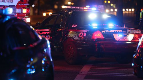 An Atlanta police officer was temporarily trapped after an accident on Spring Street at North Avenue shortly after 9 p.m., police said. BEN GRAY / BGRAY@AJC.COM