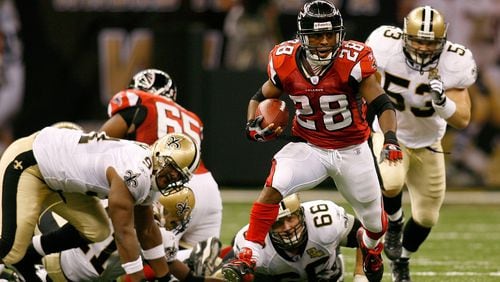 Former Falcons running back Warwick Dunn runs the ball in the second quarter of a Monday Night Football game against the Saints on September 25, 2006, in New Orleans, Louisiana. This was the first game played in the Superdome after the Saints were absent for a year because of damage sustained during the 2004 Hurricane Katrina.