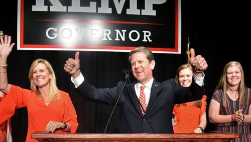 GOP gubernatorial candidate Brian Kemp gives a thumb up Tuesday as he takes the stage with his family during his election watch party in Athens. HYOSUB SHIN / HSHIN@AJC.COM