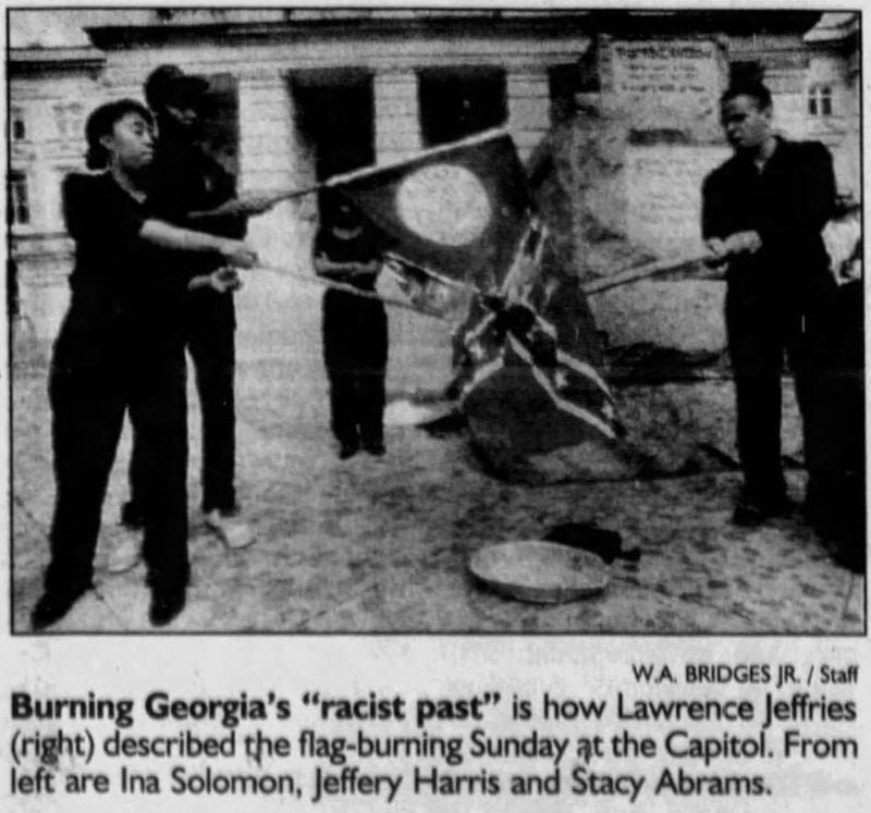 This June 1992 photo in The Atlanta Journal-Constitution shows Stacey Abrams and others burning the flag on the steps of the state Capitol. The caption identifies her as “Stacy Abrams.”