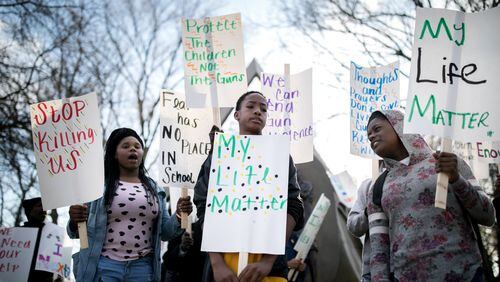 Morgan Waller (left), 16, Cody Johnson (center), 14, and Orianna Lowe, 11, hold signs during a protest of gun violence along with other students and members of the community March 9, 2018, in Atlanta. BRANDEN CAMP / SPECIAL TO THE AJC