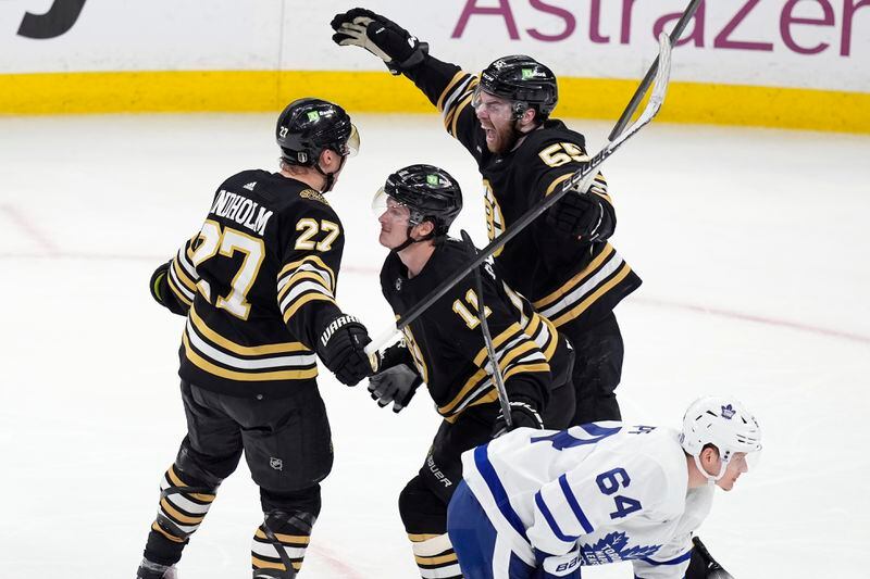 Boston Bruins' Hampus Lindholm (27) celebrates his goal with Justin Brazeau (55) and Trent Frederic (11) behind Toronto Maple Leafs' David Kampf (64) during the third period of Game 7 of an NHL hockey Stanley Cup first-round playoff series, Saturday, May 4, 2024, in Boston. (AP Photo/Michael Dwyer)
