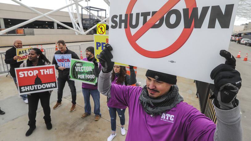 Air traffic controller, Rafael Naveira (right) and fellow controllers rallied at Hartsfield-Jackson International Airport on Jan. 14 calling for an end to the federal shutdown. JOHN SPINK/JSPINK@AJC.COM