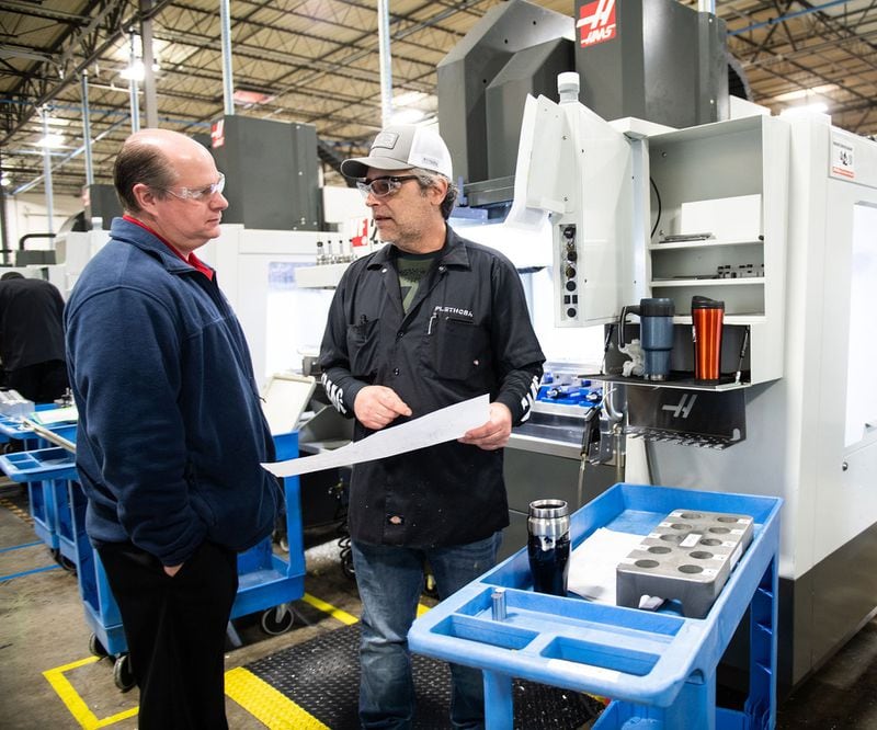 (L-R) Plant manager Rob Ireton talks with machinist three Ken Chase at Plethora, a company that makes custom prototypes, in Marietta in December. PHOTO BY ELISSA BENZIE