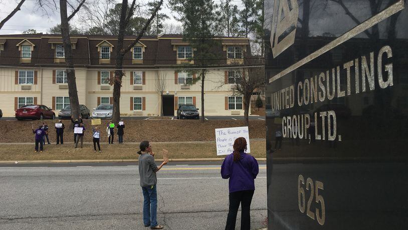 A handful of protesters showed up Monday afternoon outside the Norcross offices of United Consulting, which employs embattled Gwinnett County Commissioner Tommy Hunter.