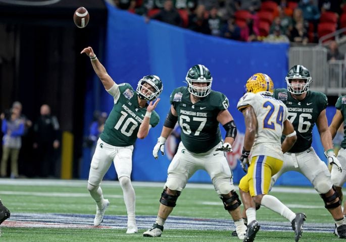 Michigan State Spartans quarterback Payton Thorne (10) attempts a pass as offensive lineman J.D. Duplain (67) and offensive tackle AJ Arcuri (76) blocks Pittsburgh Panthers linebacker Phil Campbell III (24) during the fourth quarter of the Chick-fil-A Peach Bowl at Mercedes-Benz Stadium in Atlanta, Thursday, December 30, 2021. JASON GETZ FOR THE ATLANTA JOURNAL-CONSTITUTION