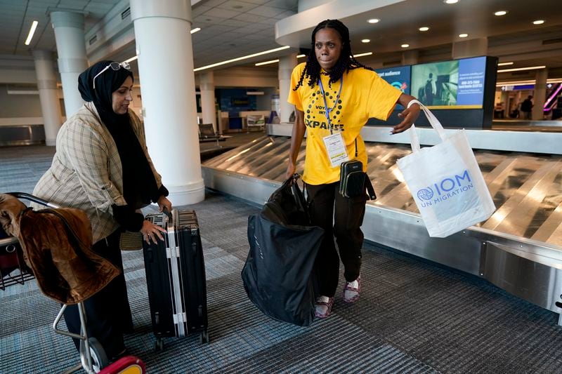 Congo refugee Aline Mugabekazi, right, with Lutheran Services Carolinas case manager Raja Alshuaibi, retrieves her bag at the airport, Wednesday, April 17, 2024, in Columbia, S.C. The American refugee program, which long served as a haven for people fleeing violence around the world, is rebounding from years of dwindling arrivals under former President Donald Trump. The Biden administration has worked to restaff refugee resettlement agencies and streamline the process of vetting and placing people in America. (AP Photo/Erik Verduzco)